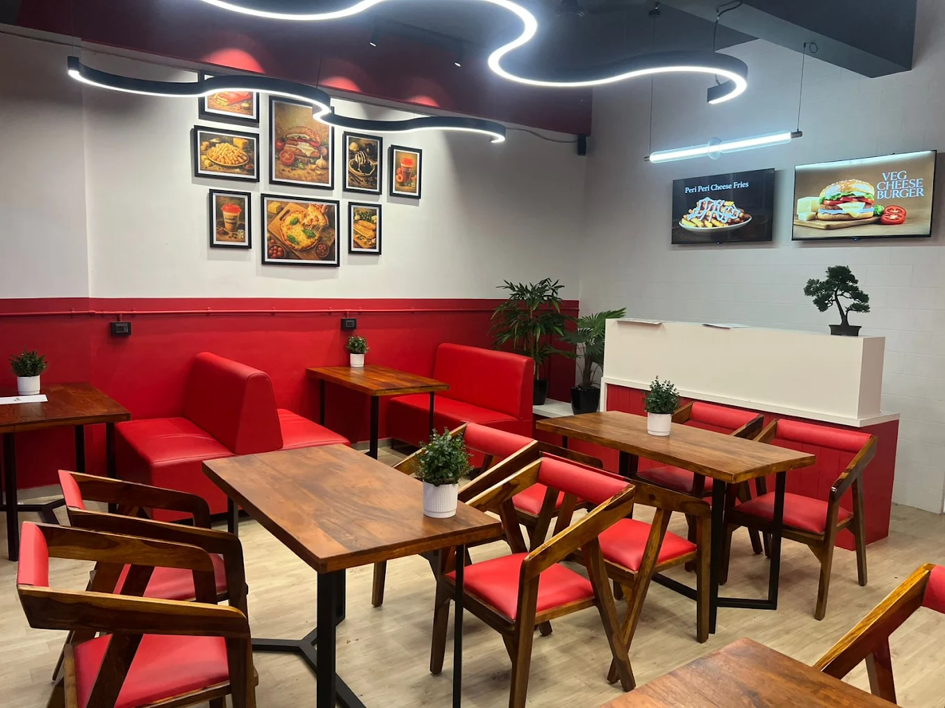 Red seating and warm wood tables inside the real Periodt Burger Bardoli outlet
