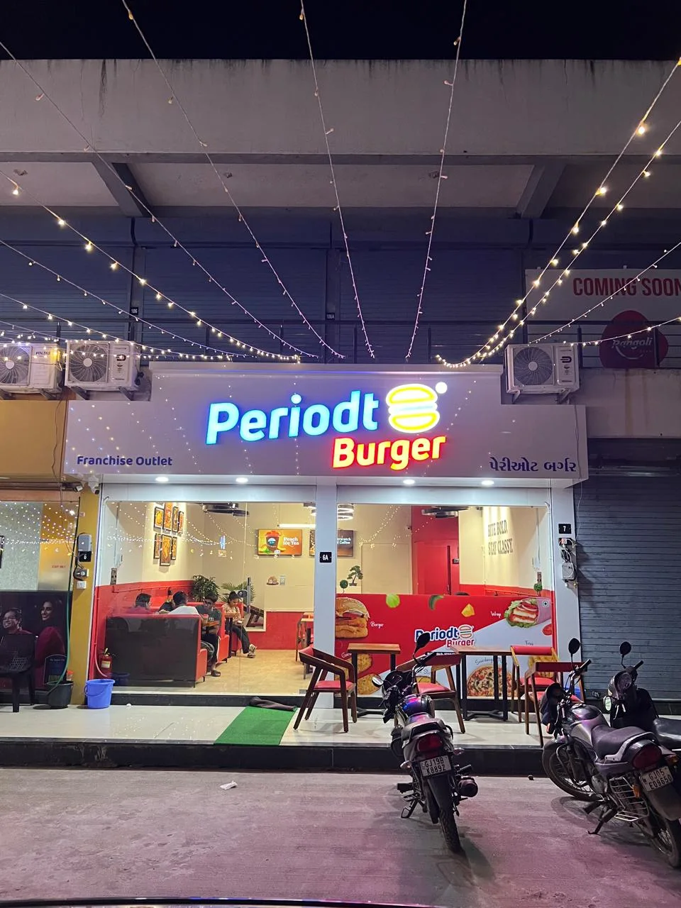 Periodt Burger Bardoli outlet with illuminated signage and seating at night
